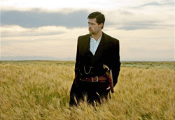 Una scena da <i>The Assassination of Jesse James by the Coward Robert Ford</i> di Andrew Dominik” />Mentre tutti aspettavano la visione dell’ultimo Allen, all’interno di una sala della Mostra si muoveva materia fertile per gli occhi e già si mescolavano rapidamente ordine e caos. <em>La zona</em> di Rodrigo Plà, piccolo grande film inserito nella sezione collaterale delle Giornate degli Autori, ha tutte le carte in regola per essere etichettato come una delle rivelazioni di questa Mostra del Cinema. Ritmo sigillato come il quartiere/location della vicenda, sceneggiatura avvincente e regia senza troppi fronzoli con virate al noir, all’horror, all’action movie sono la forma di un contenuto spiazzante e carico di significato. Il frullatino di generi è ben assortito e racconta la paura contemporanea dell’uomo che si nasconde, che scappa dalla realtà e che sostiene di potercela fare da solo.</p>
<p>Poi Woody offre una nuova variazione al tema colpa/rimorso e il suo <em>Cassandra’s Dream</em>, con la coppia di fratelli Mc Gregor-Farrel, anche se non inserito in Concorso, è sembrato uno dei migliori film visti fin’ora. Certo, a volte il giocattolino sembra lo stesso di <em>Match Point</em>, eppure la scrittura di Allen raggiunge i toni raffinati e pungenti di sempre, gli attori sono al top e tutto ciò che insegue o s’aggrappa al sogno di Cassandra assume un fascino perverso, ombroso, disperato. In fondo, anche qui, si parla di ordine scomposto, cioè di caos. Senza rovinare eventuali sorprese, l’intruso si vantava di aver fatto partire l’applauso in sala (fischi e buu, invece, alla Filmauro per questioni organizzative legate alla proiezione del film).</p>
<p>L’altro maestro inserito nella sezione Fuori Concorso è stato Claude Chabrol, con <em>La Fille coupée en deux</em> nel quale spicca l’intrigante e sensuale Ludivine Sagnier (sempre più brava, e bellina). Sfumature rosanero con tocchi di ironia si strusciano abilmente su di una scrittura brillante e fresca, fatta di equivoci, sorrisini, incastri, fregature. I colpi di scena non mancano, ma non sono gli unici che fanno spiccare il volo al film. Divertente e sconsolato.</p>
<p>Il Concorso torna di moda nella tarda mattinata di domenica con il bandit-movie di Andrei Dominik <em>The Assassination of Jesse James by the Coward Robert Ford</em> con Brad Pitt e Casey Affleck (grande prova la sua). Un racconto spietato e duro alla scoperta di ciò che spinse il fanatico Robert Ford all’uccisione del bandito Jesse James, da tutti temuto e amato per la sua efferatezza. Una tragica (e infinita) vicenda fatta di lunghe panoramiche, virate malinconiche, pistole e scorribande feroci, che nonostante l’attesa (soprattutto delle fan di Brad Pitt) non ha esaltato particolarmente i palati del pubblico. Gli applausi, comunque, non sono mancati (neppure da parte dell’intruso, anche se stavolta non li ha lanciati).</p>
<p>Chiude il cerchio caotico/ordinato l’ottimo esordio di Andrea Molaioli con <em>La ragazza del lago</em>. Forte di un cast che vanta Toni Servillo, Fabrizio Gifuni e Valeria Golino tra gli altri, il film ha sicuramente convinto e entusiasmato. Il giallo costruito perfettamente sulla figura di Servillo-detective è tratto da un romanzo norvegese (<em>Lo sguardo di uno sconosciuto</em> di Karin Fossum) e vista la tensione narrativa, l’abilità di ripresa, la scrittura di Petraglia molto convincente e puntuale, l’intruso si chiedeva una cosa: “Ma Petraglia non si sente solo nel mondo degli sceneggiatori italiani?”. Applausi e speranze, ma questa volta la distribuzione non ostacolerà (vero?!)</p>
<p>Questa sera c’è Wes. Domani Kechiche, Wen e Haynes.<br />
Meno sei e l’intruso è sul treno.</p>
				<p class=